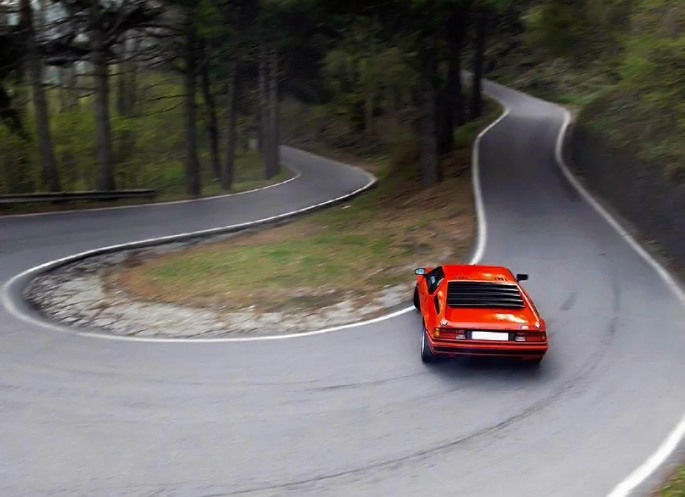 BMW M1 drifts through a hairpin bend