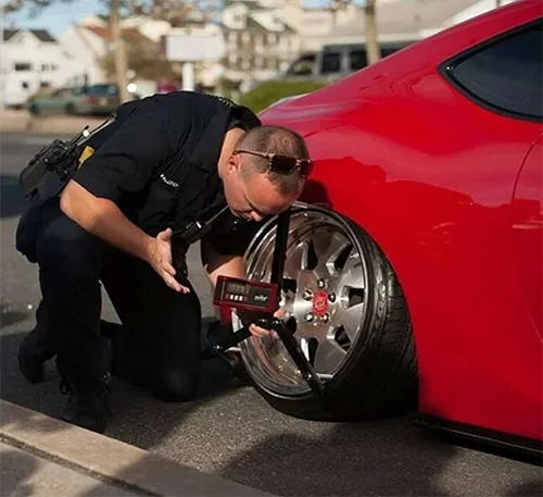 Police officer checking camber angle