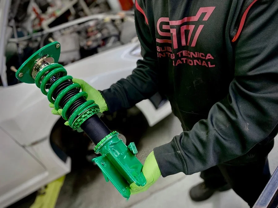 Technician holding a Tein coilover