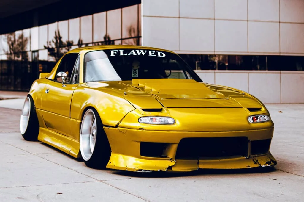 Mustard yellow NA Miata with rolled fenders