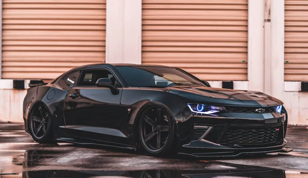 Lowered, black Camaro with Factory Reproduction Wheels