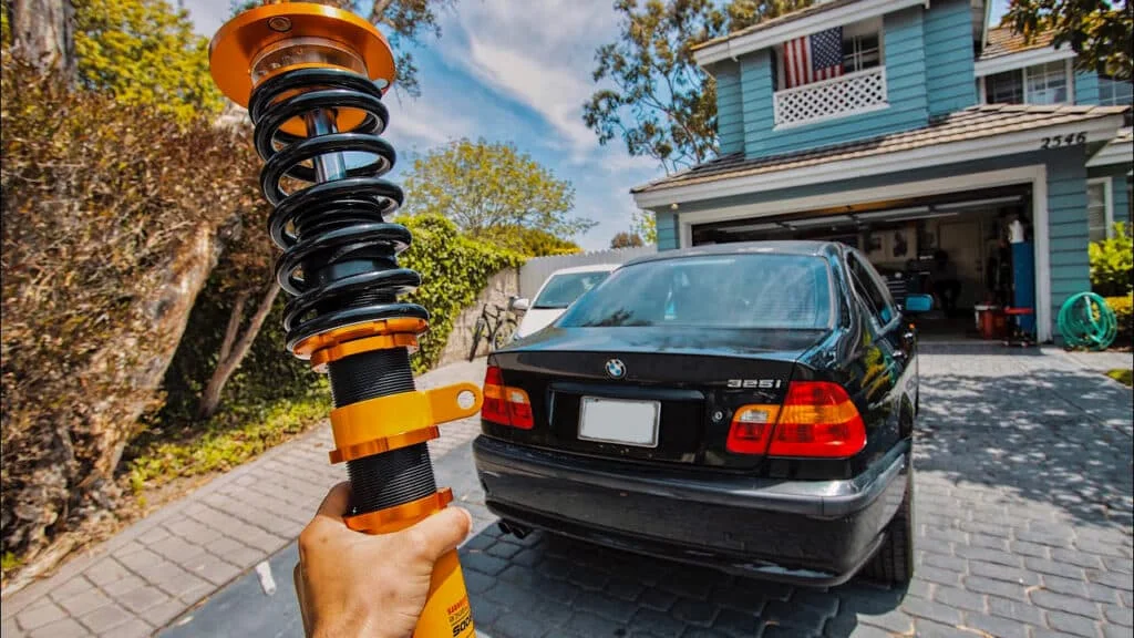 Person holding a yellow coilover unit