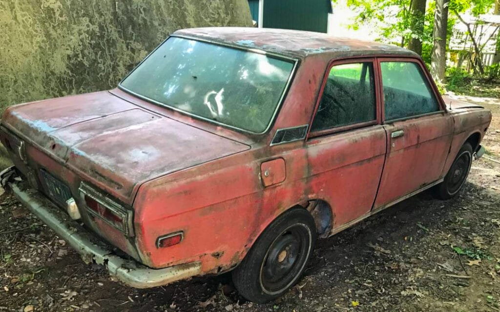 Datsun 510 sitting outdoors without use