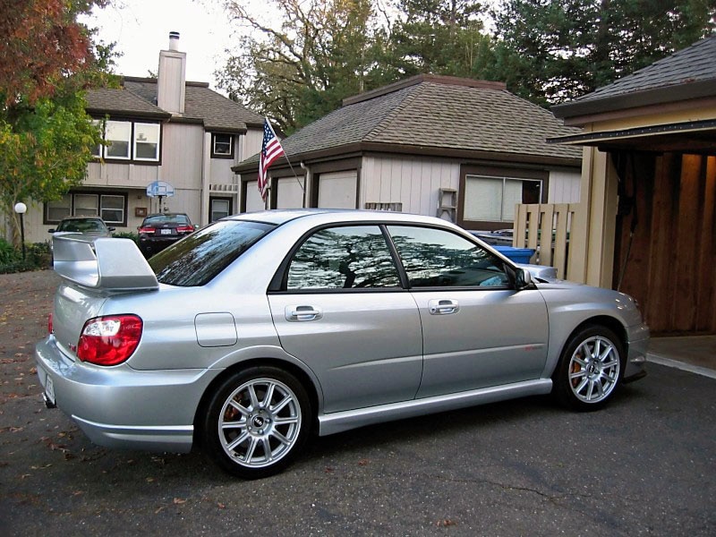 A silver Subaru WRX with mirror window tint