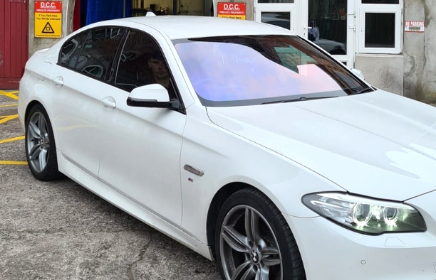 White BMW sedan with reflective front windshield