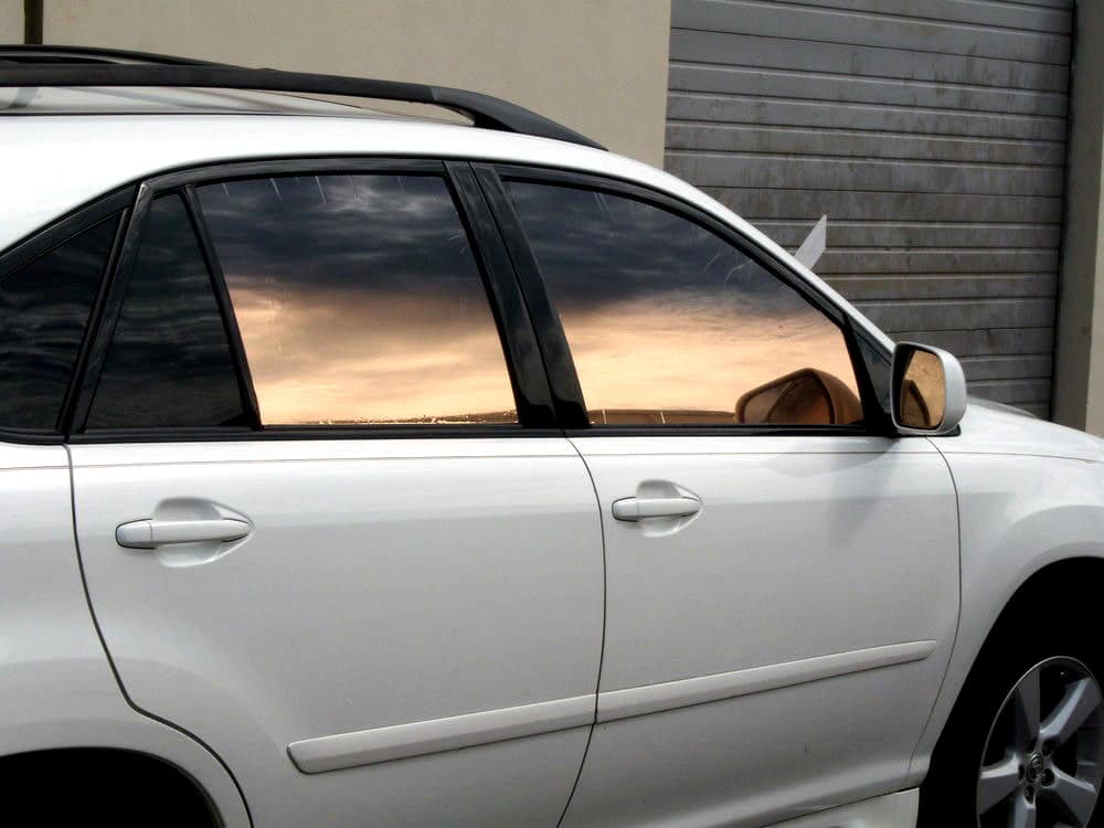 Bronze reflective window tint on white sedan