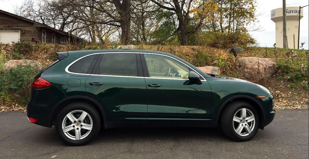 Green Porsche Cayenne with tinted rear windows.