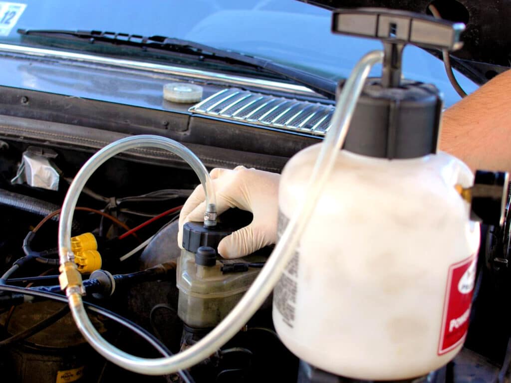 Pressure tank brake bleeder attached to master cylinder reservoir