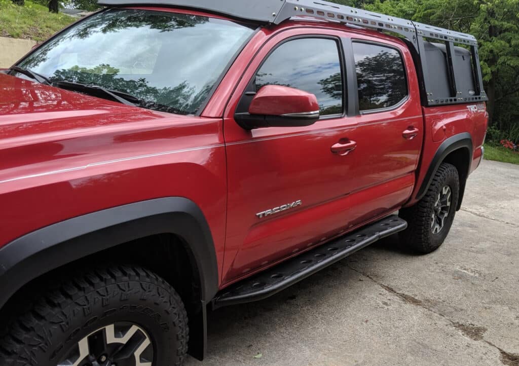 SOS Concepts rock slider installed on a red Tacoma