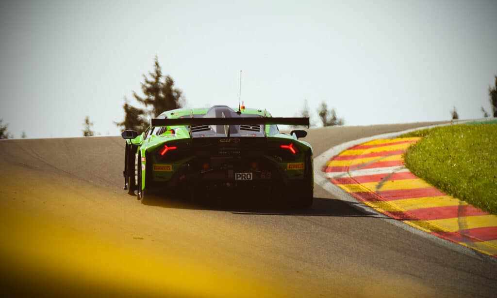 Green Lamborghini accelerating out of a corner