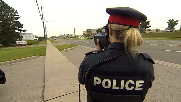 Police officer pointing Spectre RDD at a car